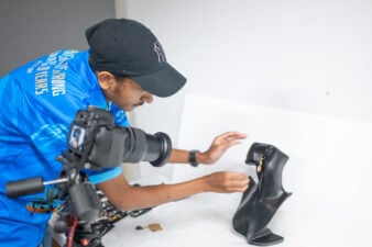 Torres Strait Islander student Neville Nona from Tagai at the back of house at Gab Titui Cultural Centre taking photos of products for sale from the Torres Strait Region