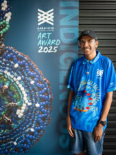 Work experience student Neville Nona from Tagai State College stands proudly infront of a banner at the Gab Titui Cultural Centre
