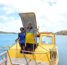 Loban Marine Founder and Owner Yen Loban with granddaughter Tei'ya Lee Mosby-Loban infront of yellow ferry in waters of the Torres Strait region