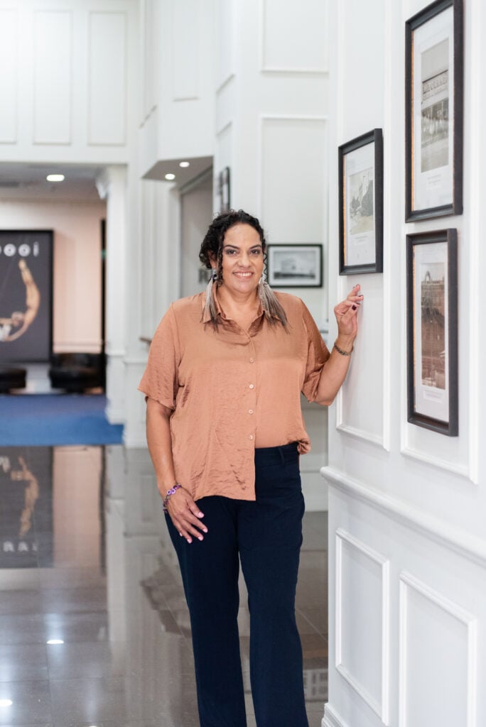 New Torres Strait Traditional Languages Association Chief Executive Officer Jillian Bowie poses infront of artwork