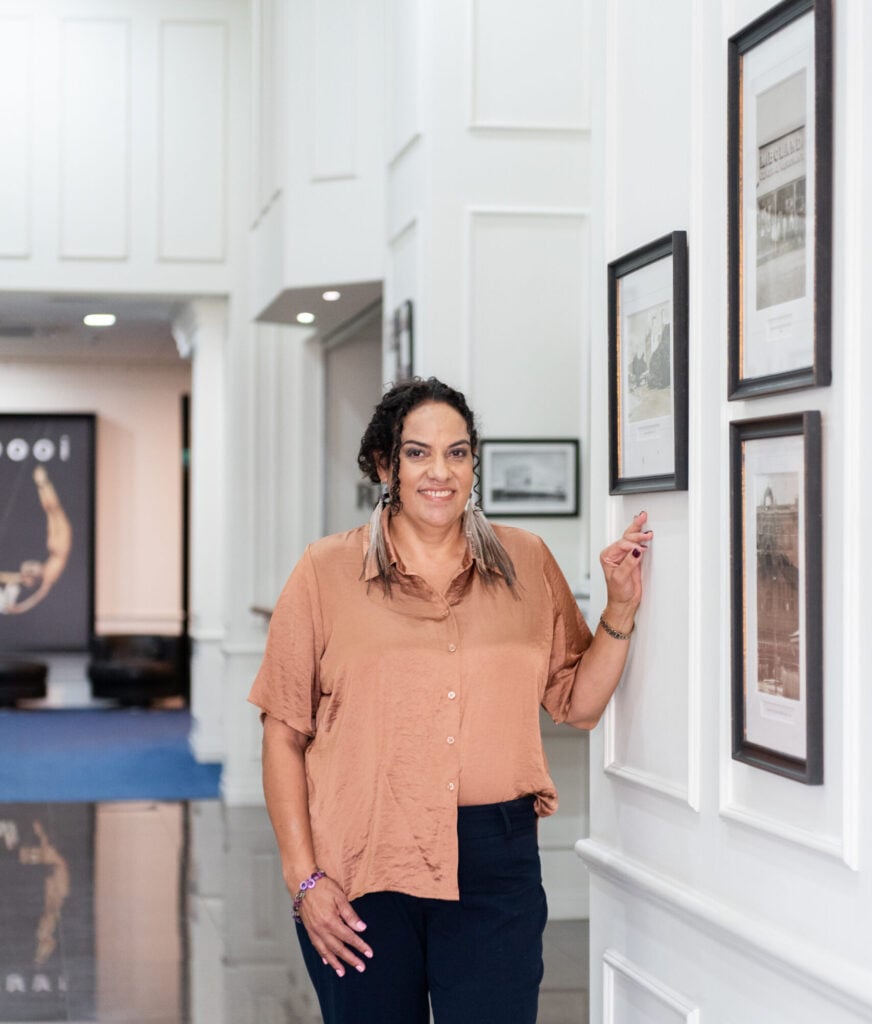 New Torres Strait Traditional Languages Association Chief Executive Officer Jillian Bowie poses infront of artwork