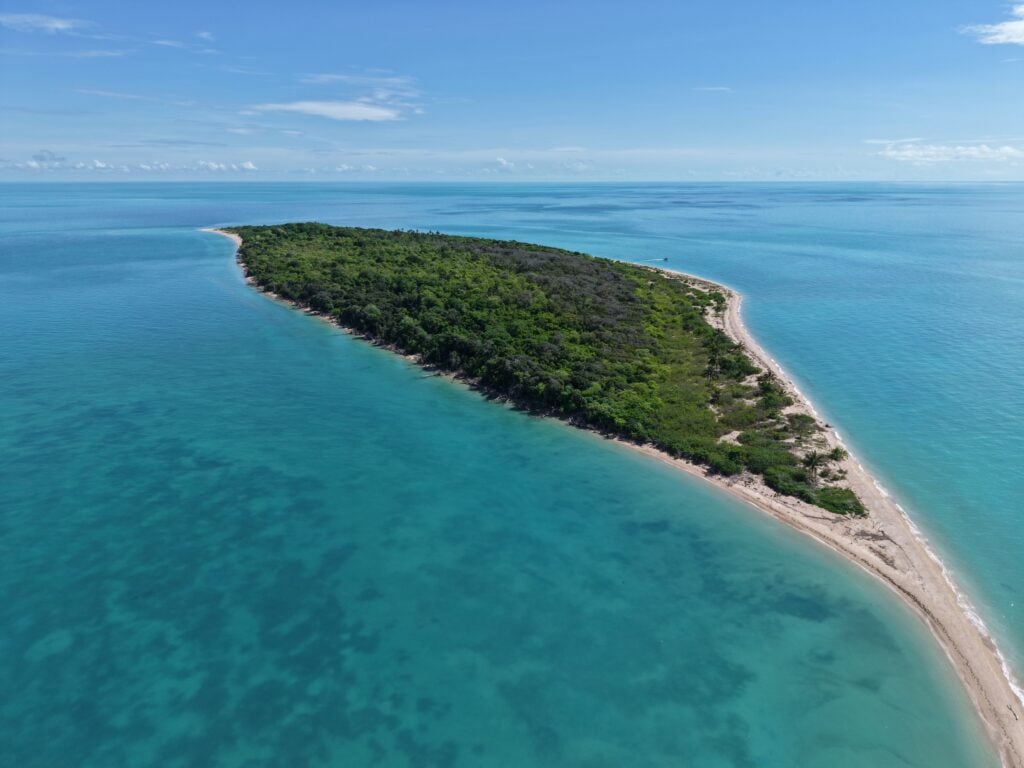 Aerial image of island Warul Kawa surrounded by blue ocean in the Torres Strait region