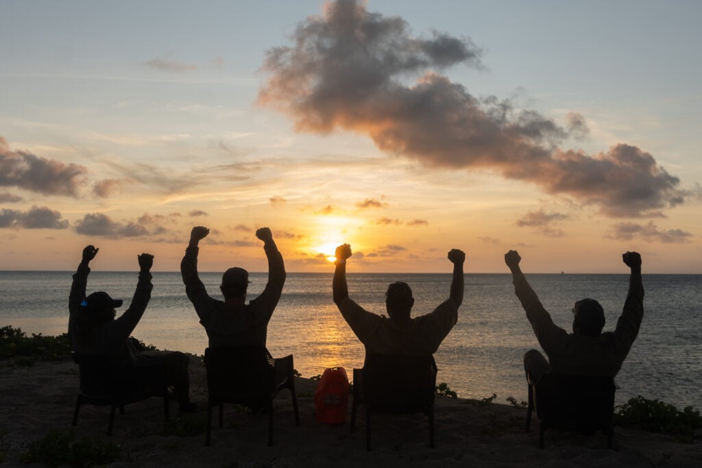 Silhouette of TSRA Rangers against a backdrop of ocean, sky and sun.