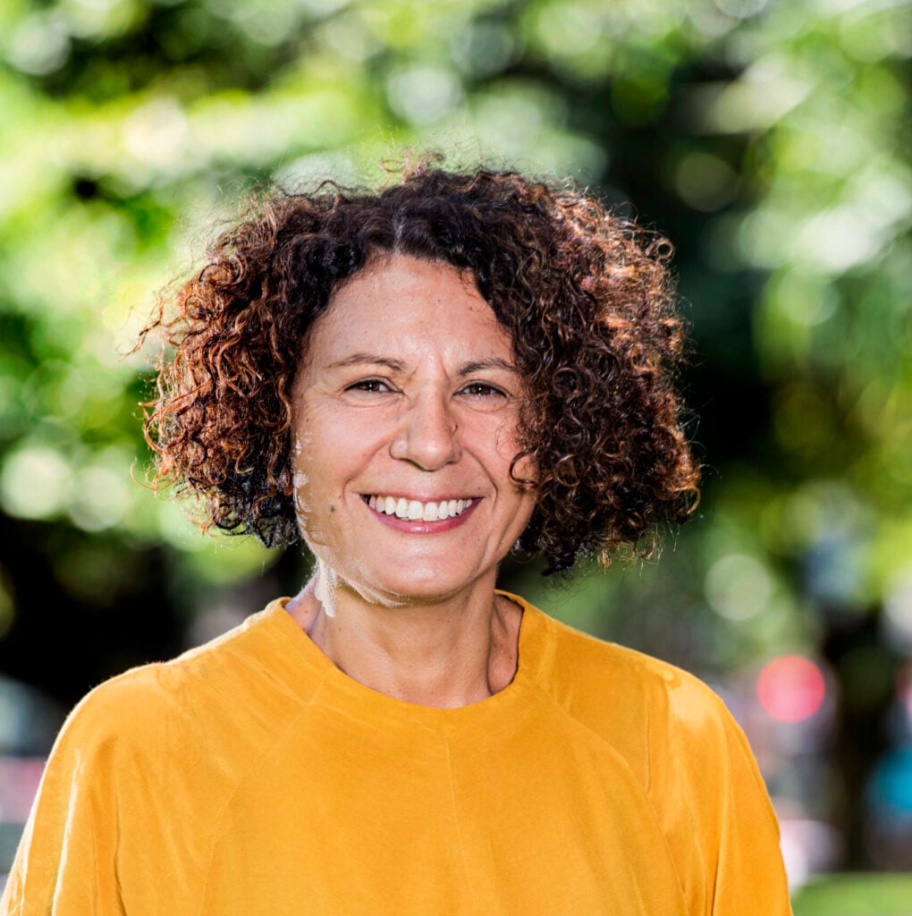 Smiling woman in yellow shirt with curly hair, Janina Harding.