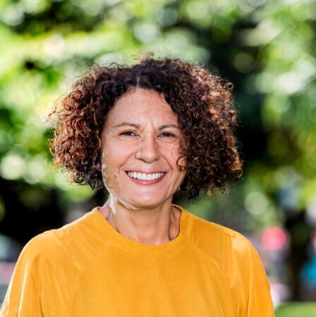 Smiling woman in yellow shirt with curly hair, Janina Harding.